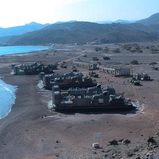 Military base with expeditionary vehicles utilizing defense communications